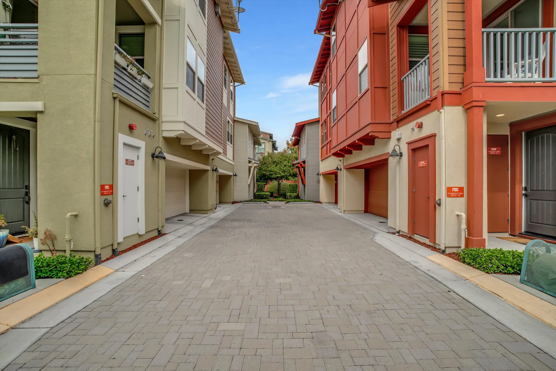 Paved drive between the red subject building and neighboring Sage residences