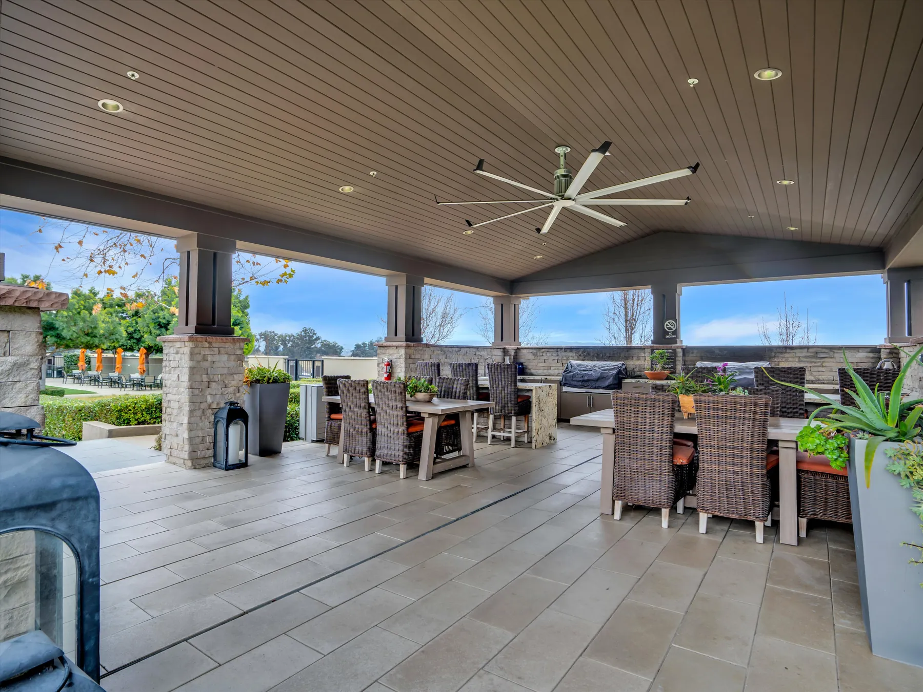 Covered Sage community patio with tables, chairs and ceiling fans