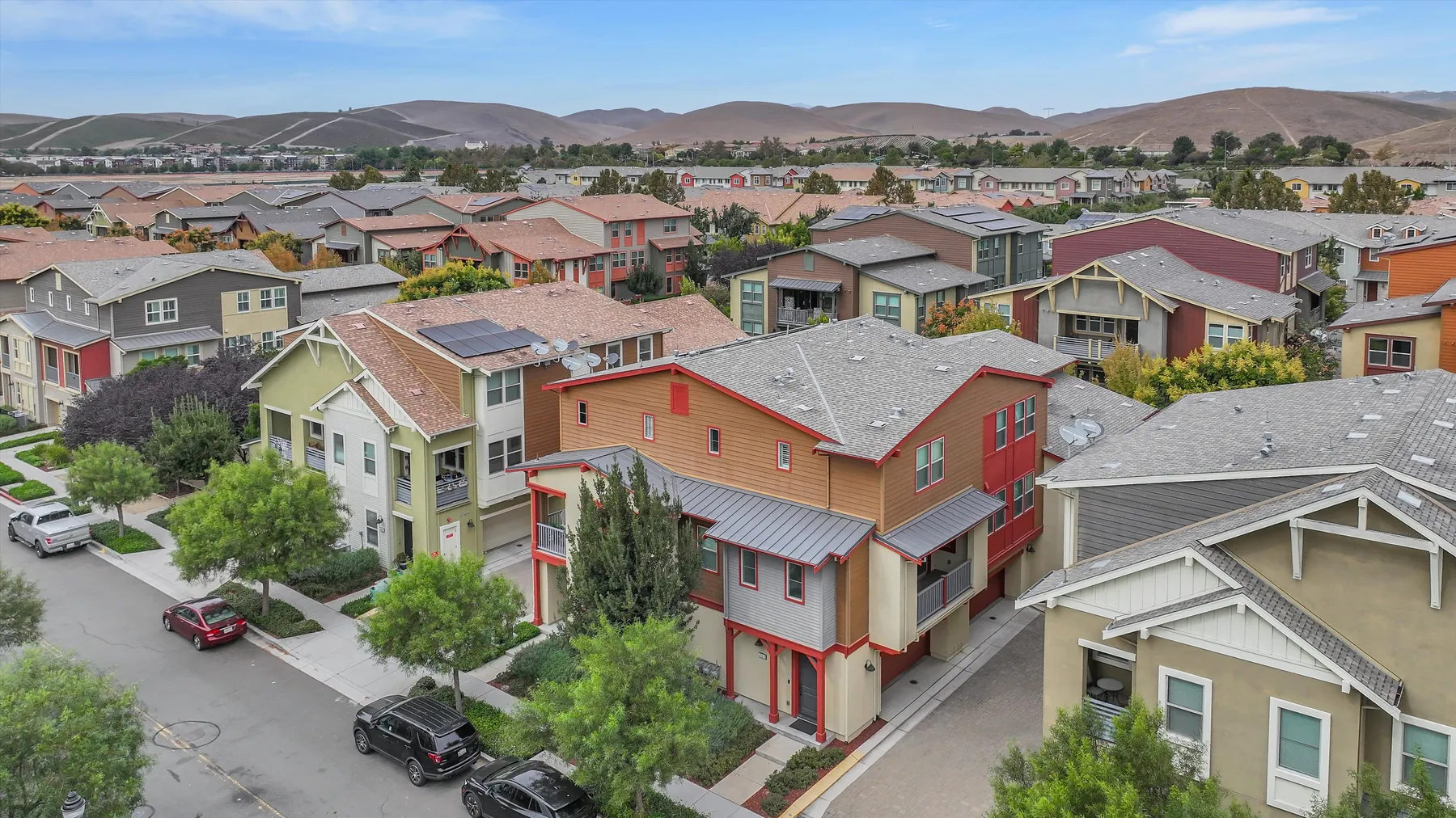 Drone view centered on the red subject building among Sage homes and distant hills